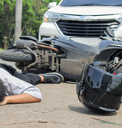 Motorcycle Accident Scene With Man Injured and Lying on Road